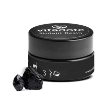 Load image into Gallery viewer, Black container of Vitadote Shilajit Resin with two pieces of black resin on a white background